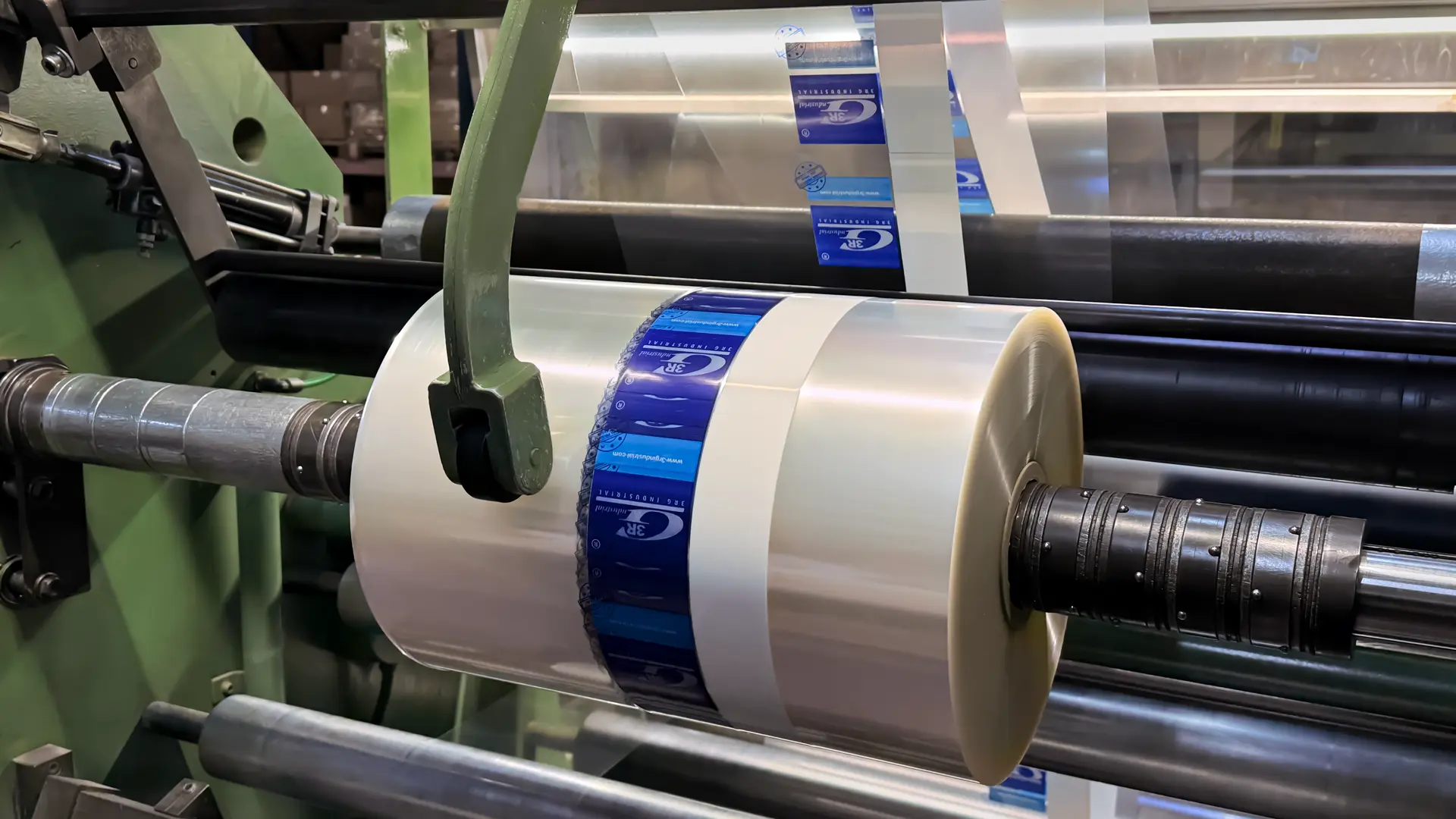 Proceso de rebobinado de film plástico transparente para embalaje industrial en la fábrica de Plásticos Coimbra